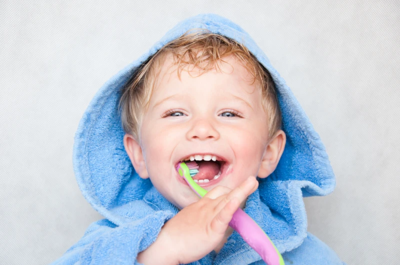 Toddler smiling with toothbrush in hand
