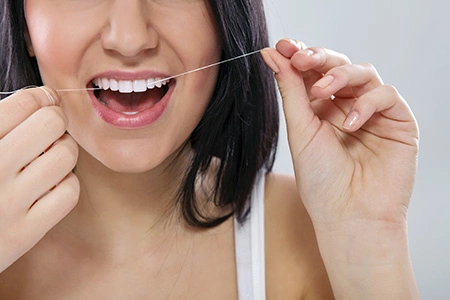Woman flossing with a smile and clean teeth